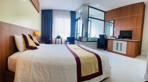 a hotel room with a large bed and a television at KHÁCH SẠN SAO MAI in Cao Lãnh