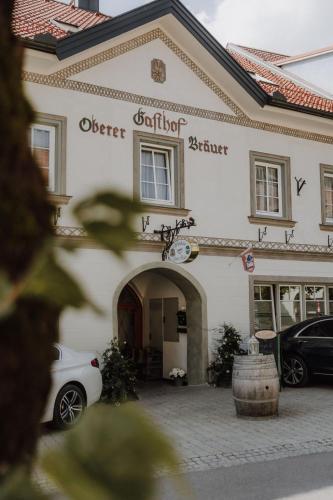 a white car parked in front of a building at Gasthof Oberer Bräuer in Oberwölz Stadt