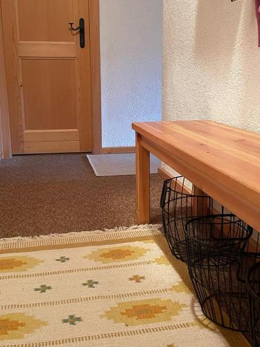 a wooden table next to a door with a rug at Fougère 11 in Champoussin
