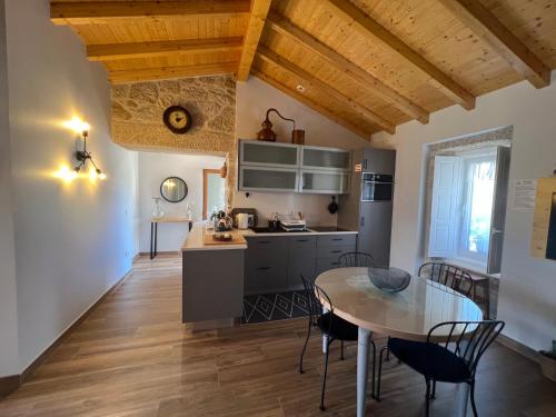 a kitchen and dining room with a table and chairs at Eido de Bairros - Casa Vinha da Touça T1 in Soajo