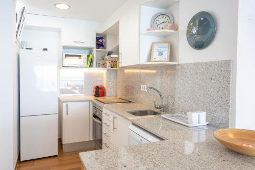a kitchen with a sink and a refrigerator at Pis Embaixador 1a línea de mar in Platja  d'Aro