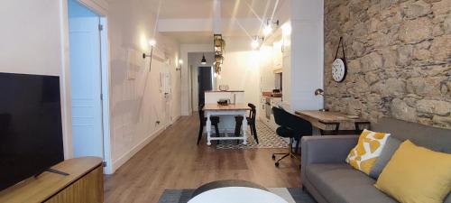a living room with a couch and a table and a desk at Calle Real con patio in Ferrol