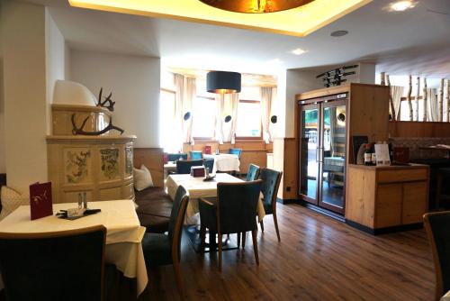 a restaurant with tables and chairs in a room at Hotel Alpenkönigin - ALPINE LUXURY in See