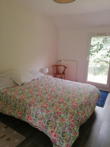 - une chambre avec un lit doté d'un couvre-lit coloré dans l'établissement Maison paisible 3 chambres proche parc expo, à Chartres-de-Bretagne