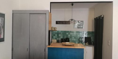 a kitchen with a counter top and a cabinet at L'Empire D'Essences Appartement in Valréas