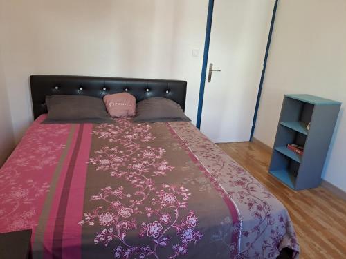- une chambre avec un lit avec une couverture rose et une armoire bleue dans l'établissement Appart à 15 minutes de la plage, à Perpignan