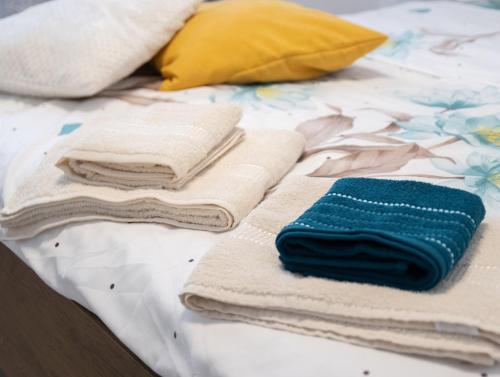 a pile of towels sitting on top of a bed at Casuta bunicilor in Volovăţ