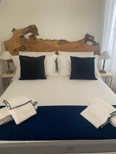 a large white bed with blue and white pillows at Porta Blu Apulia in Martina Franca