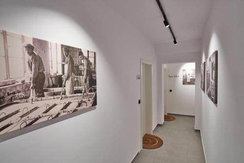 a hallway with black and white photographs on a wall at Alte Seifensiederei - Thay in Bad Tölz