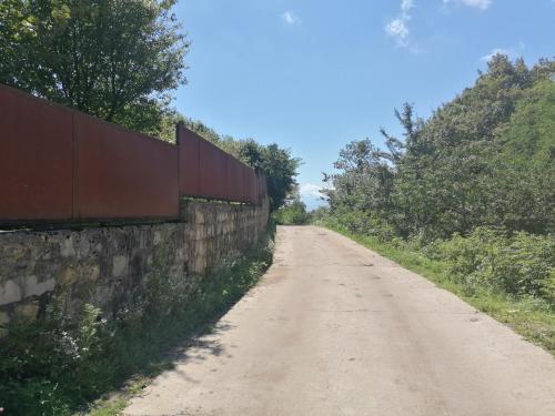 a dirt road next to a retaining wall at GoGni OLD ROOM in Gogni