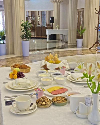 a table filled with plates and bowls of food at Ametist Hotel Complex in Samarkand