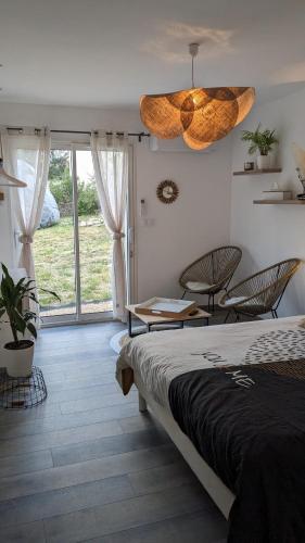 une chambre avec un lit et un lustre dans l'établissement Chez Marion, à Saint-Bonnet-du-Gard