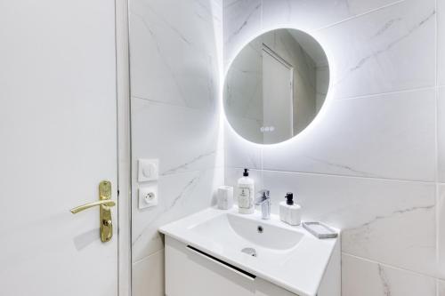 a white bathroom with a sink and a mirror at Appartement - 4 personnes - Parking Privé - Métro 7 - Rer B in La Courneuve