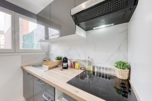 a kitchen with a sink and a counter top at Appartement - 4 personnes - Parking Privé - Métro 7 - Rer B in La Courneuve