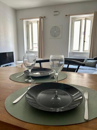 - une table avec une assiette noire et des verres à vin dans l'établissement La Cachette Albigeoise, APPARTEMENT PLEIN CENTRE, PARKING GRATUIT SECURISE, à Albi