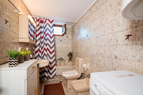 a small bathroom with a toilet and a sink at Ilia house in Volos