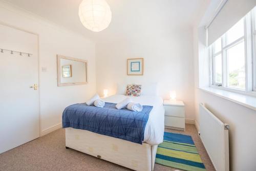 a bedroom with a bed with a blue blanket at Chestnutt Cottage, Reydon in Reydon