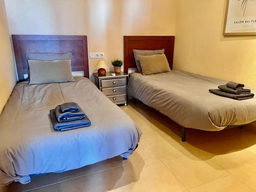 Dos camas en una habitación con toallas encima. en Condado de Alhama PENTHOUSE 8 SV24, en El Romero