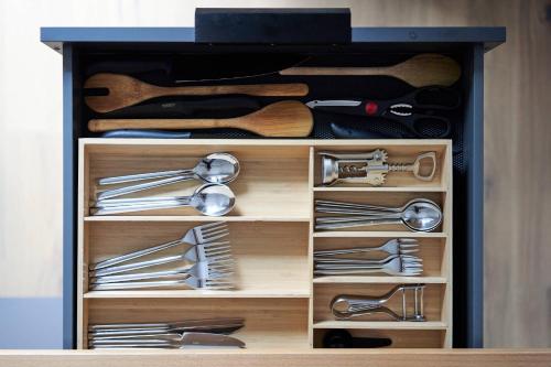 a wooden cabinet filled with lots of cooking utensils at Alte Seifensiederei - Lallaji in Bad Tölz
