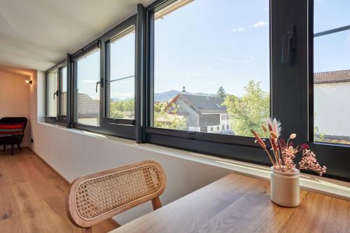 a room with large windows with a chair and a table at Alte Seifensiederei - Lallaji in Bad Tölz