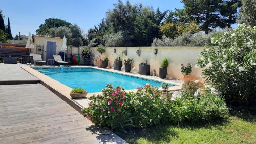 - une piscine dans une cour ornée de fleurs et de plantes dans l'établissement Maisonnette en campagne au calme, à Carpentras