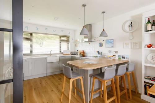 a kitchen with a large wooden table and chairs at Pretty Coastal Home in Bosham Close to Water in Bosham
