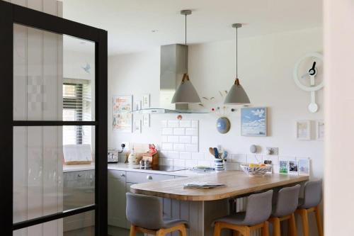 a kitchen with a wooden table and chairs at Pretty Coastal Home in Bosham Close to Water in Bosham