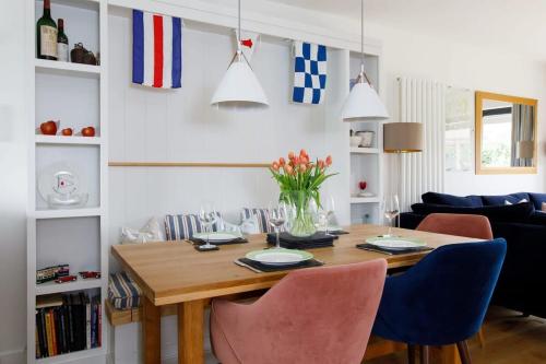 a dining room with a wooden table and chairs at Pretty Coastal Home in Bosham Close to Water in Bosham