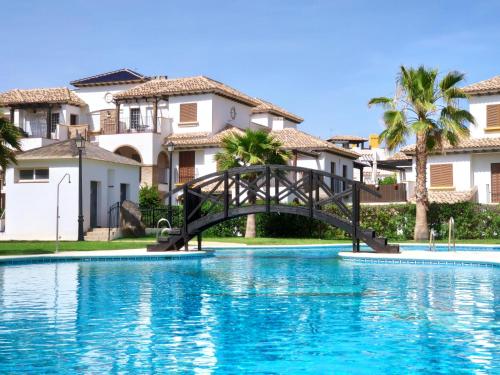 a bridge over a pool in front of some houses at RELAX en Vera Playa con SPA in Vera