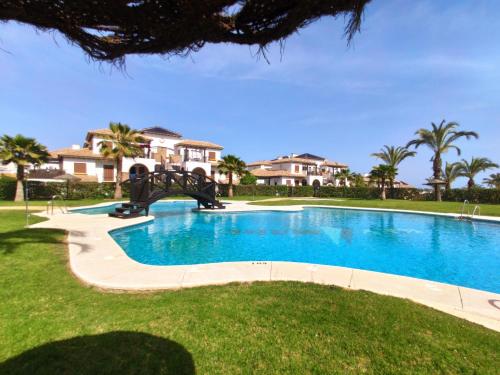 a swimming pool in a yard with houses in the background at RELAX en Vera Playa con SPA in Vera