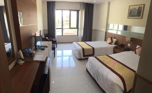 a hotel room with two beds and a desk at KHÁCH SẠN SAO MAI in Cao Lãnh