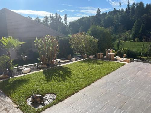 a garden with grass and plants in a yard at Residenza San Remy in Unterkulm
