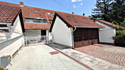a house with a garage and a driveway at Alea Apartmanok in Harkány