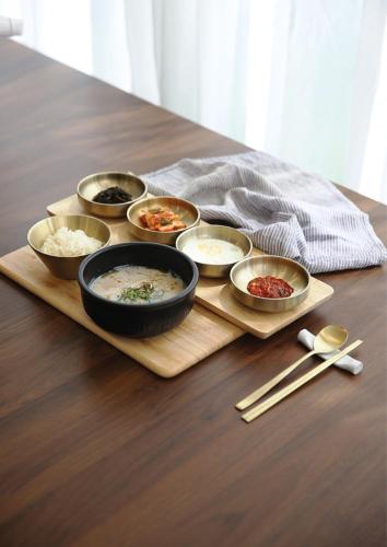 a tray with bowls of food on a table at 어라연 관광호텔 영월 in Yeongwol