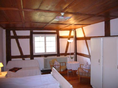 コンスタンツにあるBurghof Wallhausenのベッドルーム1室(ベッド1台付)、木製の天井が備わるベッドルーム1室が備わります。