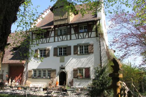 ein Gebäude mit Tischen und Stühlen davor in der Unterkunft Burghof Wallhausen in Konstanz