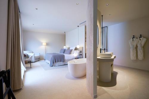 a bathroom with a bed and a tub in a room at 1881 Hotel Balneario Vichy Catalan in Caldes de Malavella