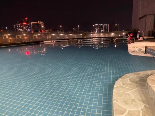 a swimming pool with a city skyline at night at WakakaPackers in Kuala Lumpur