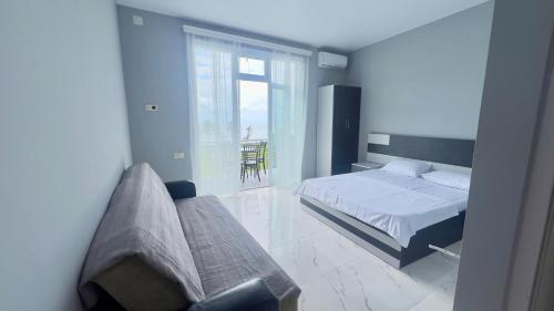 a bedroom with a bed and a couch and a window at Grand Hotel Kobuleti in K'obulet'i