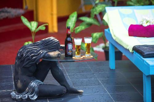 a statue of a bear holding a table with two drinks at Arcadia Resort in Hikkaduwa