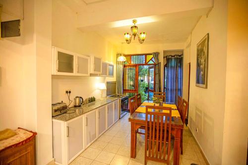 a kitchen with a table and a dining room at Arcadia Resort in Hikkaduwa