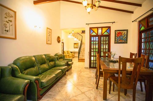 a living room with a green couch and a table at Arcadia Resort in Hikkaduwa