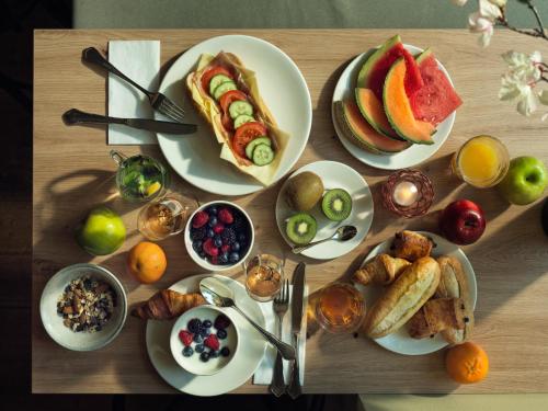 a wooden table with plates of breakfast food on it at Townhouse Maastricht & Spa in Maastricht