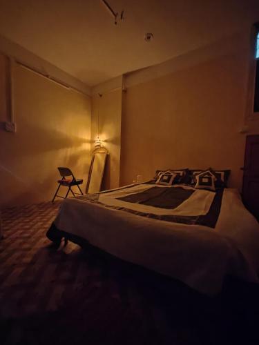 バラナシにあるRudravasa Luxury Stayの部屋にベッドと椅子がある寝室