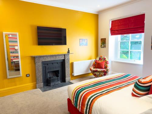 a yellow room with a bed and a fireplace at Dunningwell Hall in Duddon
