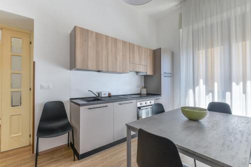 a kitchen with a table and chairs and a kitchen with a table and a counter at Casette del Pescatore - HelloElba in Portoferraio