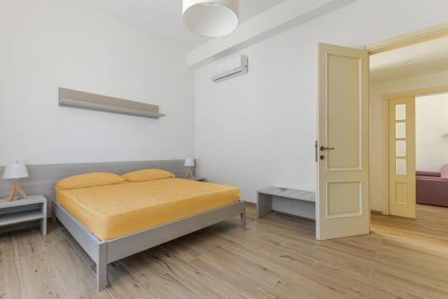 a white bedroom with a bed and a door at Casette del Pescatore - HelloElba in Portoferraio