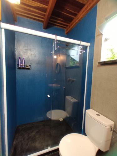 a bathroom with a toilet and a glass shower at Suíte em Lumiar - Hospedaria Casa Quíron in Lumiar