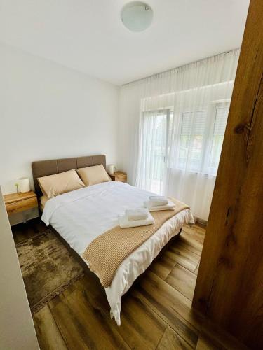 a white bedroom with a large bed with white sheets at Villa Nina in Vrnjci