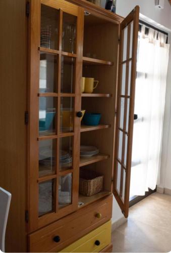 a wooden cabinet with glass doors in a kitchen at Romantic Stone- Studio apartman in Omiš